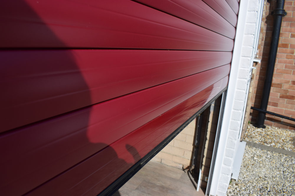 Red roller shutter garage door half open